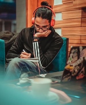 man writing with headsets on